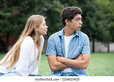 Teenager Girl Trying To Kiss Distracted Boyfriend. Hispanic Boy Ignoring Girlfriend