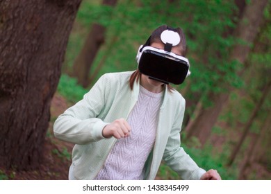 Teenager Girl Wearing Virtual Reality Goggles Outside In Spring Nature