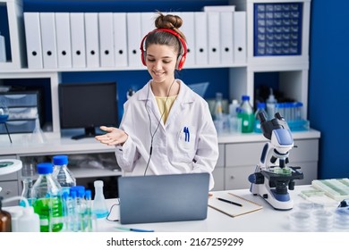 Teenager girl working at scientist laboratory celebrating achievement with happy smile and winner expression with raised hand 