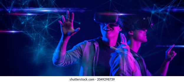 Teenager having fun play metaverse VR virtual reality glasses Esport game futuristic neon colorful background, future digital technology NFT game and entertainment - Shutterstock ID 2049298739