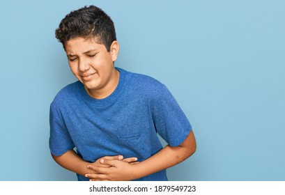 Teenager hispanic boy wearing casual clothes with hand on stomach because indigestion, painful illness feeling unwell. ache concept. 