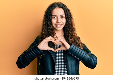 Teenager Hispanic Girl Wearing Black Leather Jacket Smiling In Love Showing Heart Symbol And Shape With Hands. Romantic Concept. 