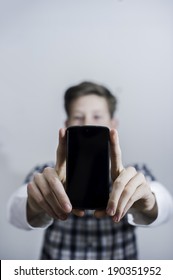 Teenager Holding Up Phone While Looking At Camera. 