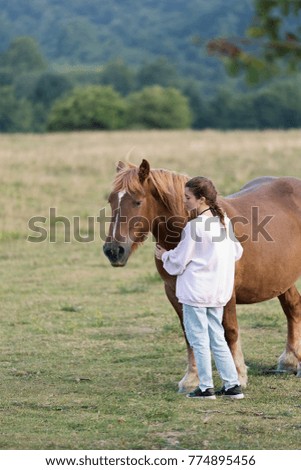 Teenager with Horses in a meadow of Navarra, Spain.