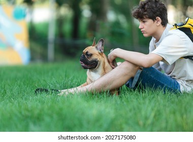 Teenager Hugs His Red French Bulldog Outside. Boy Walking With Cute Bulldog In The Park. Still Life, Friendship With A Dog	