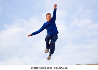 Teenager Jumping Against The Sky. Parkour On The Sand