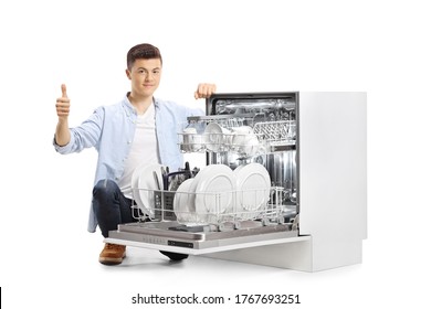 Teenager Kneeling Next To A Dishwasher And Showing Thumbs Up Isolated On White Background