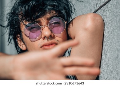 teenager leaning on the wall in the street with a rebellious gesture - Shutterstock ID 2310671643