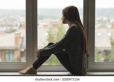 teenager loneliness,sad depressed teen girl sitting on the window,frustrated young woman,problems and misfortunes in her family and life - Shutterstock ID 2030971154