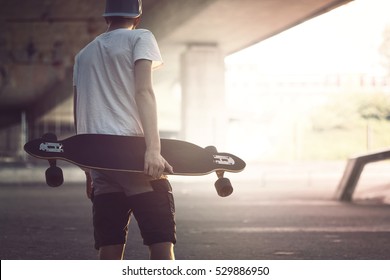 Teenager with longboard in the city