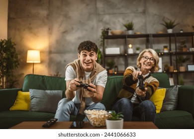 teenager male and his mother mature woman man play console video game - Powered by Shutterstock