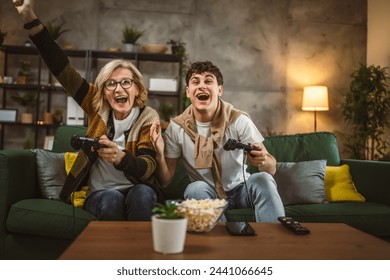 teenager male and his mother mature woman man play console video game - Powered by Shutterstock