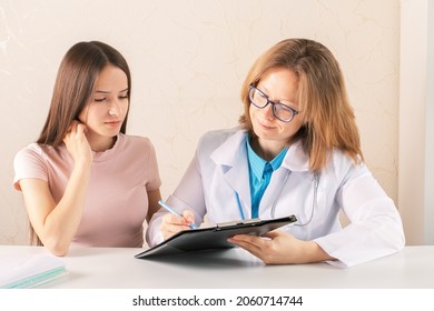 Teenager At Medical Consultation With A Doctor In Medical Office,nurse Explains The Appointments To The Woman,tells How To Take Medications And Take Care Of Health