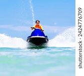 Teenager on jet ski. Teen age boy skiing on wave runner. Young man on personal watercraft in tropical sea. Active summer vacation for school child. Sport and ocean activity on beach holiday.