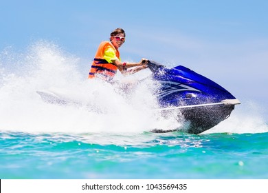 Teenager On Jet Ski. Teen Age Boy Skiing On Water Scooter. Young Man On Personal Watercraft In Tropical Sea. Active Summer Vacation For School Child. Sport And Ocean Activity On Beach Holiday