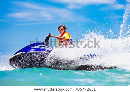 Teenager on water scooter. Teen age boy skiing. Young man on personal watercraft in tropical sea. Active summer vacation for school child. Sport and ocean activity on beach holiday.