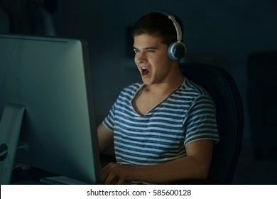 Teenager Playing Computer Game At Home Late In Evening