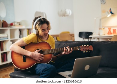 teenager playing guitar at home.