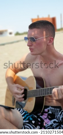 Similar – Young Boy Enjoying Music Playing Guitar Outdoors