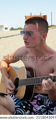 Young Boy Enjoying Music Playing Guitar Outdoors