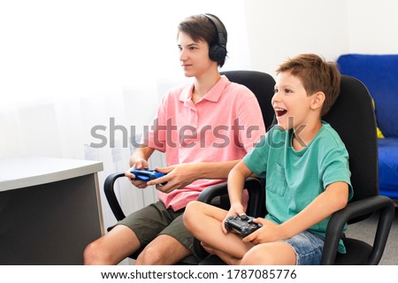 Teenager plays a computer game with headphones and a joystick, game console.