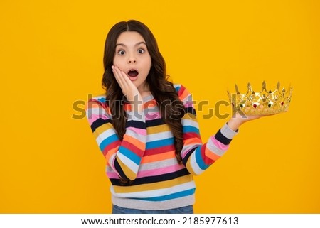 Teenager princess child celebrates success win and victory. Teen girl in queen crown. Shocked amazed face, surprised emotions of young teenager girl.