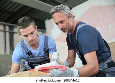 Teenager With Professional Brick Layer In Training School