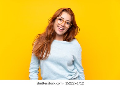 Teenager Redhead Girl Over Isolated Yellow Background With Glasses And Happy