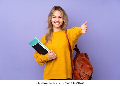 Teenager Russian student girl isolated on purple background presenting and inviting to come with hand - Shutterstock ID 1646180869