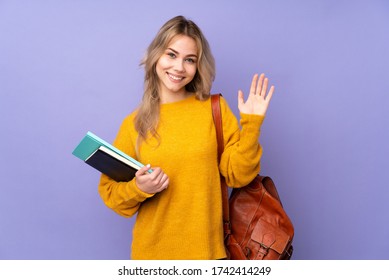 Teenager Russian student girl isolated on purple background saluting with hand with happy expression - Shutterstock ID 1742414249