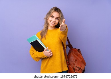 Teenager Russian student girl isolated on purple background shaking hands for closing a good deal - Shutterstock ID 1896723673