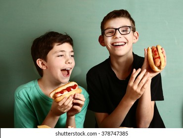 Teenager School Boys Cooking Eat Hot Dog Happy Smiling Laughing Closeup Portrait On Blue Wall Background