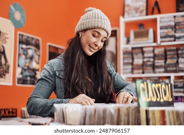 Teenager, shopping and vinyl in record store with music, vintage and retro song search. Young woman, retail shop and gen z student with browsing for second hand audio and thrift collection on sale - Powered by Shutterstock