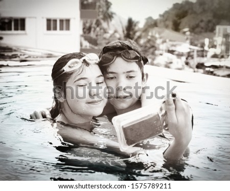 teenager siblings brother and sister make selfie in the swimming pool with special waterproof camera close up photo