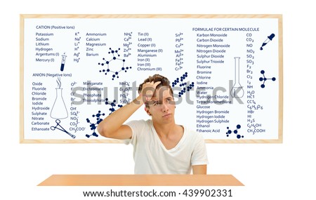 Teenager sitting at desk in front of white board with Chemistry Positive and Negative Ions and Molecule whiteboard
