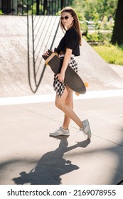 Teenager Skater Girl Holding A Skateboard An Standing In The Skaters Park