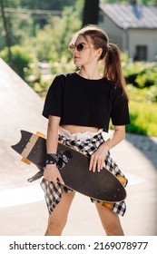 Teenager Skater Girl Holding A Skateboard An Standing In The Skaters Park