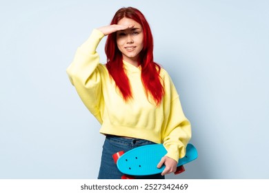 Teenager skater girl isolated on white background looking far away with hand to look something - Powered by Shutterstock