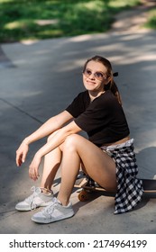 Teenager Skater Girl Is Sitting On Skateboard On The Skaters Park