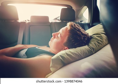 Teenager Sleeping In The Backseat Of A Car On A Trip