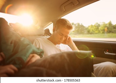 Teenager sleeping in the backseat of a car on a trip - Powered by Shutterstock