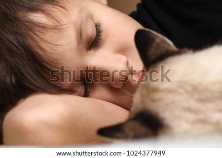 Newborn baby with pompom hat sleeping on blanket