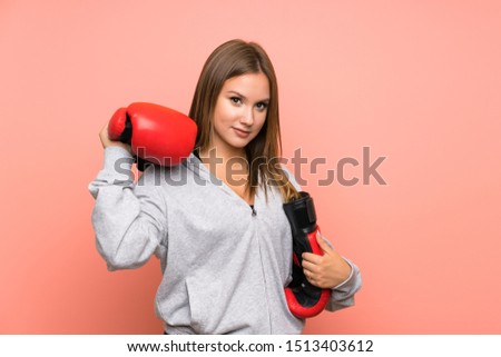 Teenager sport girl with boxing gloves over isolated pink background