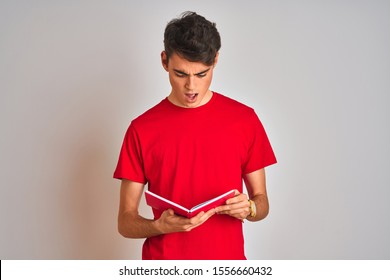 Teenager student boy reading a book over isolated background scared in shock with a surprise face, afraid and excited with fear expression