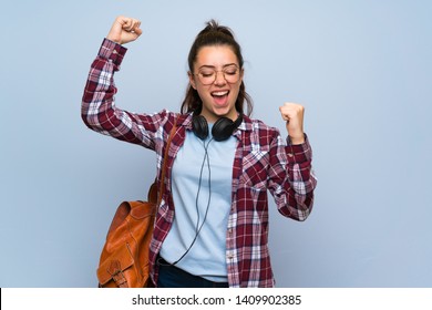 Teenager Student Girl Over Isolated Blue Wall Celebrating A Victory