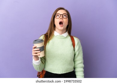 Teenager student girl over isolated purple background looking up and with surprised expression