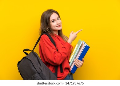 Teenager Student Girl Over Yellow Background Pointing Finger To The Side