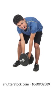 Teenager trying to carry a very heavy dumbbell on his face suffering reaction, isolated on white background