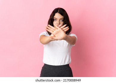 Teenager Ukrainian girl isolated on pink background making stop gesture with her hand to stop an act - Shutterstock ID 2170008949