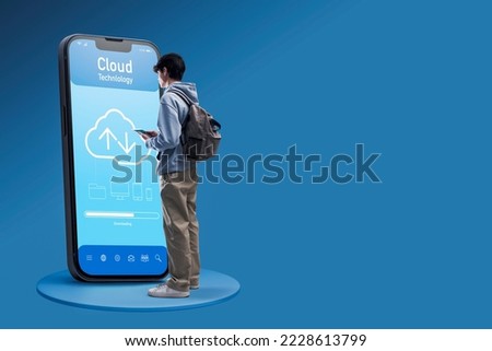 Teenager using a cloud application on a big smartphone, data storage and security concept, copy space